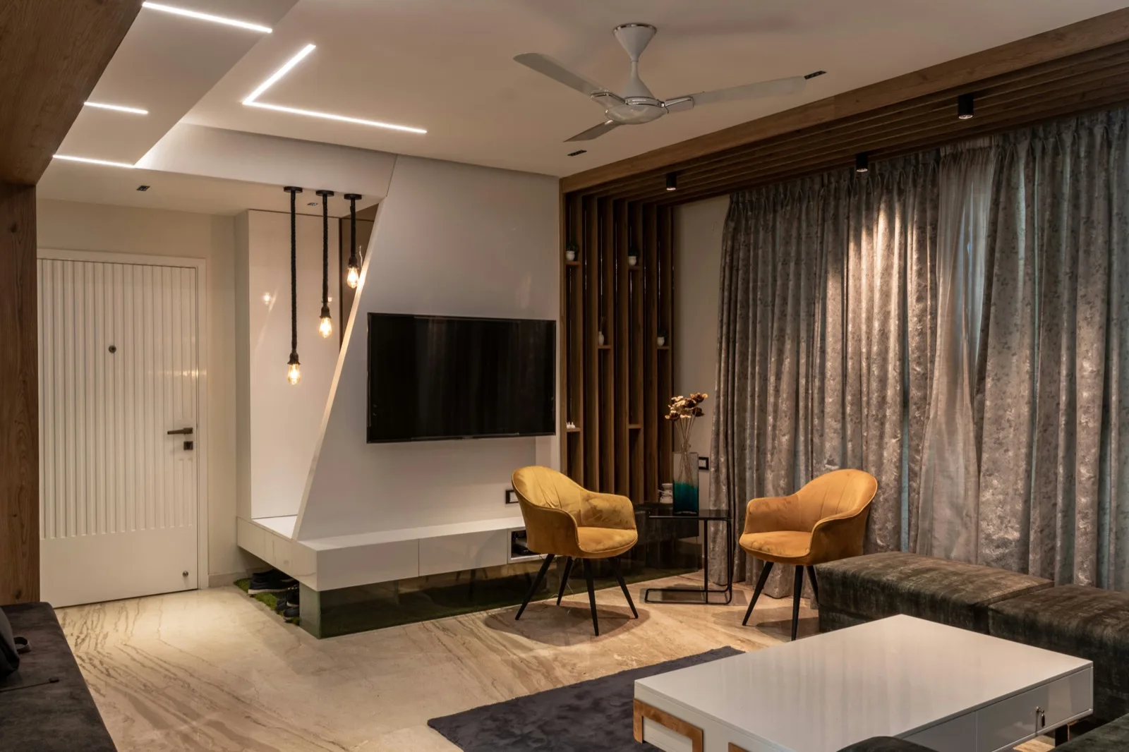 Living room with TV wall and pendant false ceiling lights Chennai